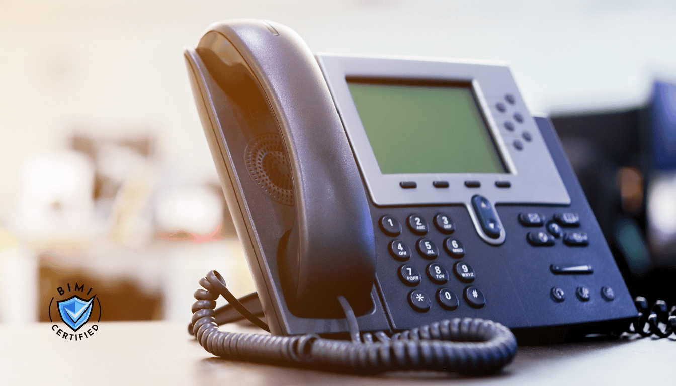 机の上に置かれ、BIMI検証の電話を待つ近代的な電話機